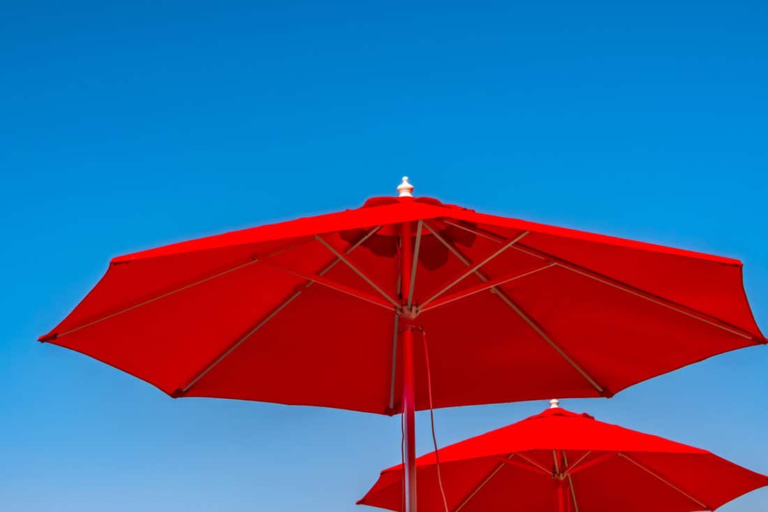 Two big red umbrellas captured on a sunny day