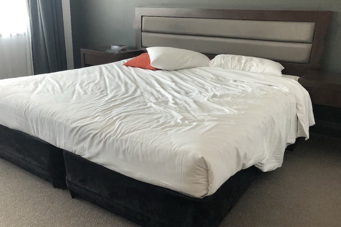 Unmade bed in an unrecognisable hotel room