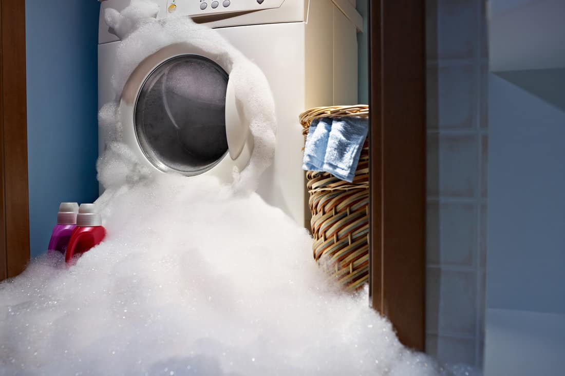 Washing machine with lots of bubble coming out of it