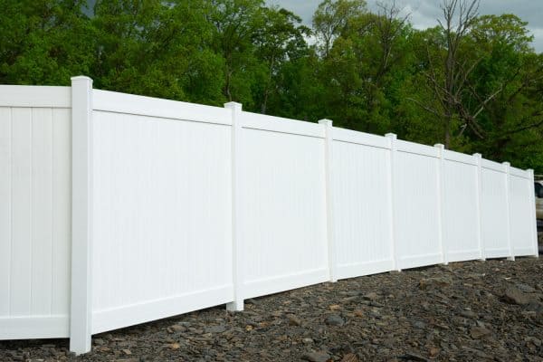 White vinyl fence fencing of private property grass plastic - How To Fill The Gap At The Bottom Of A Fence [Inc. Vinyl, Wood, And More]