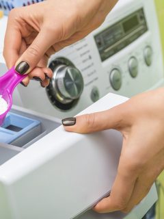 Woman throws laundry detergent into the washing machine close-up, How Much Powder Detergent To Use In Washing Machine [And Where To Put It]