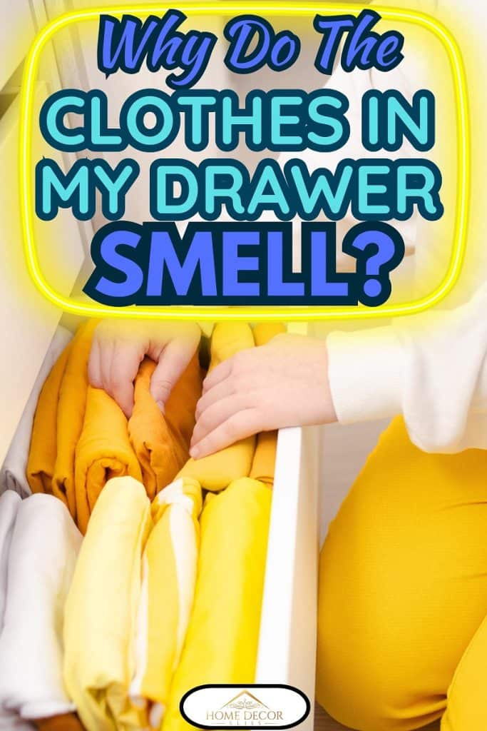 Women's hands fold yellow clothes into a closet drawer.