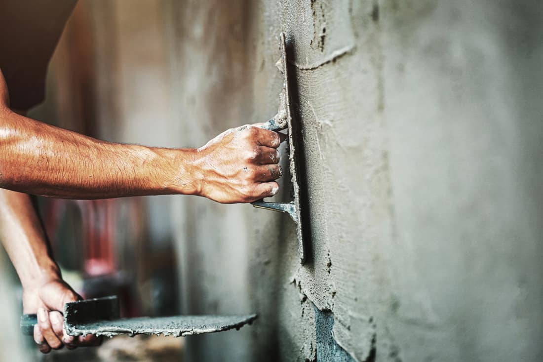 Worker plastering a concrete wall