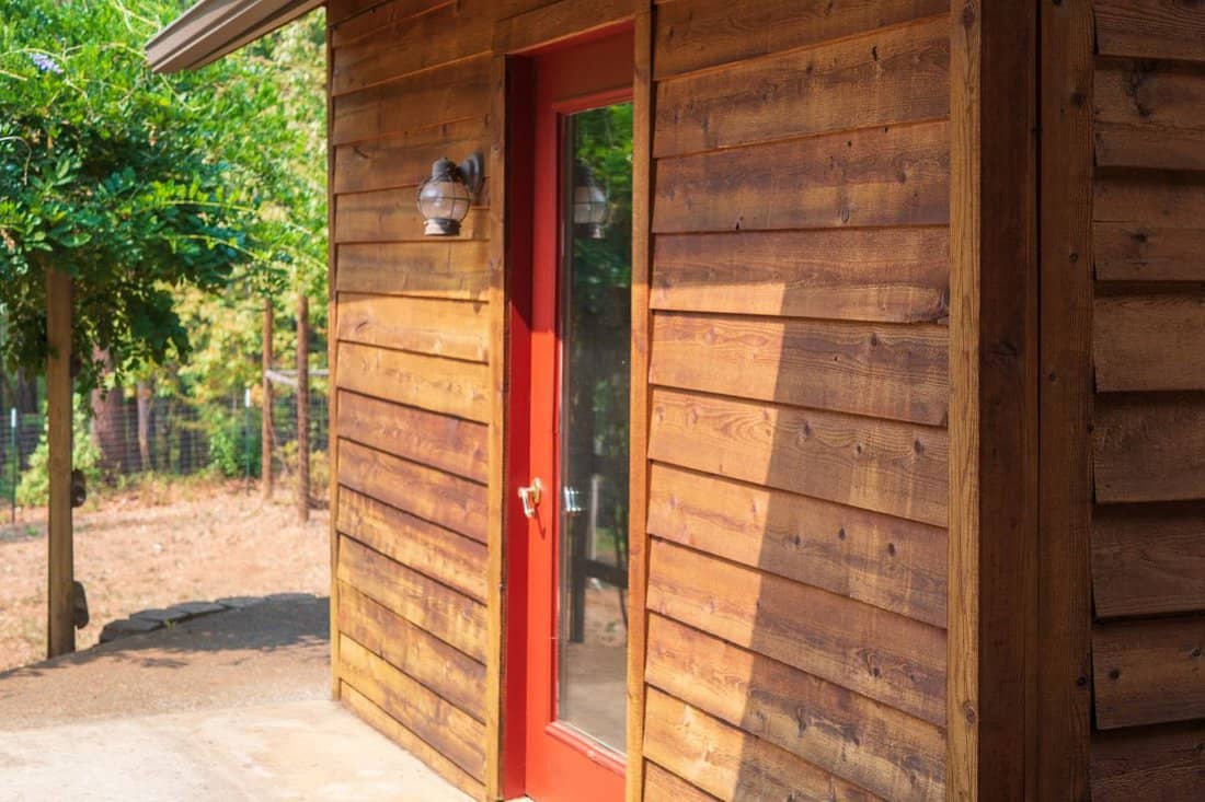 cedar sided house with red door