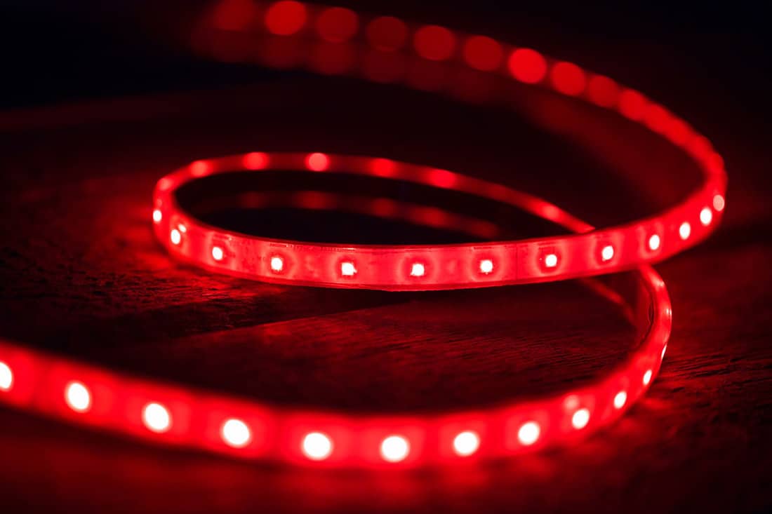 close up photo of a bright red colored led strip lights on a black background