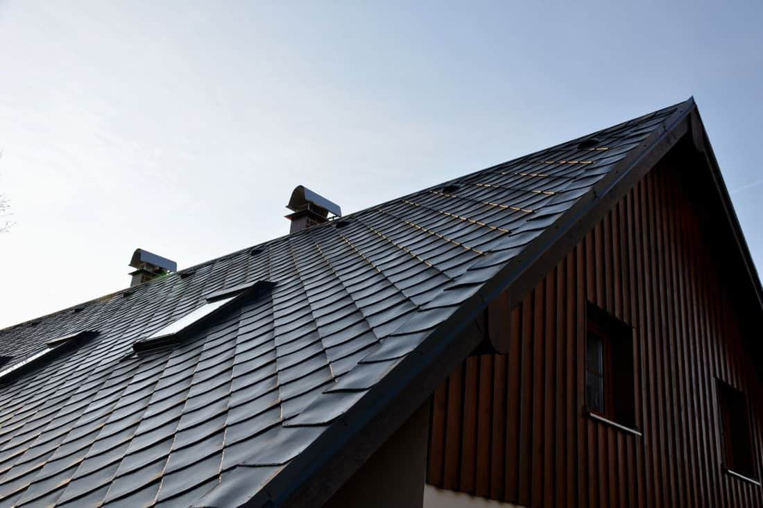 gray roof tiles with windows square slate template. square grid pattern. the lower edge of the roof is formed by a metal strip for framing better tearing off layer of snow heat transfer through