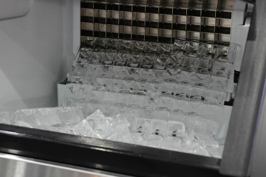 ice cubes store in ice making machine for clean product ; industrial background