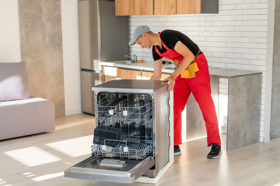 master-installing-dishwasher-kitchen-cabinet
