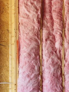 photo of a pink-insulation inside the walls of the room, Should You Insulate Interior Walls?