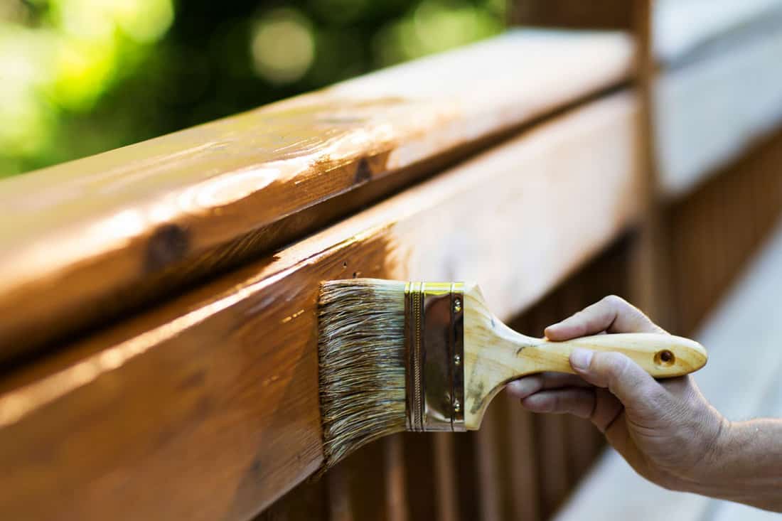 professional painting the wood with exterior stain