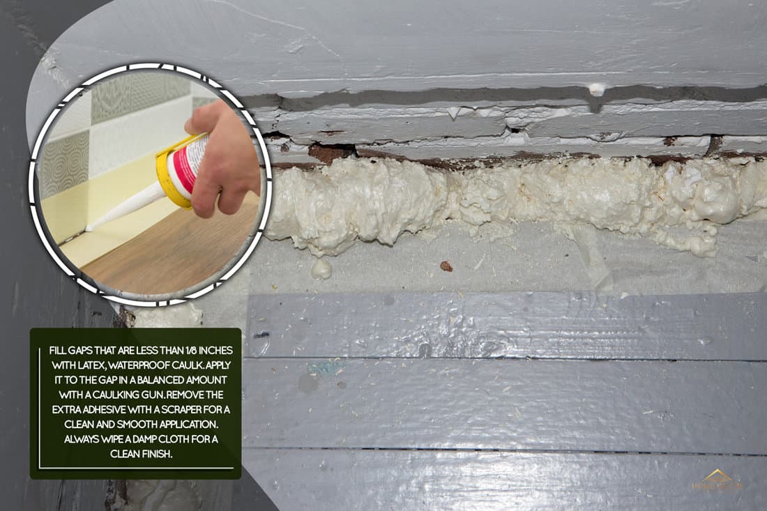 Expanding foam at the base of a wall to seal the gap between the wall and the floor boards - the foam needs be trimmed ready for sand papering before painting. Polyurethane Foam filling a gap., How To Fill Gaps Between Cupboards & Walls [Step By Step Guide]