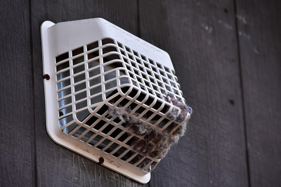 A dryer air vent accumulating dirt on its grills