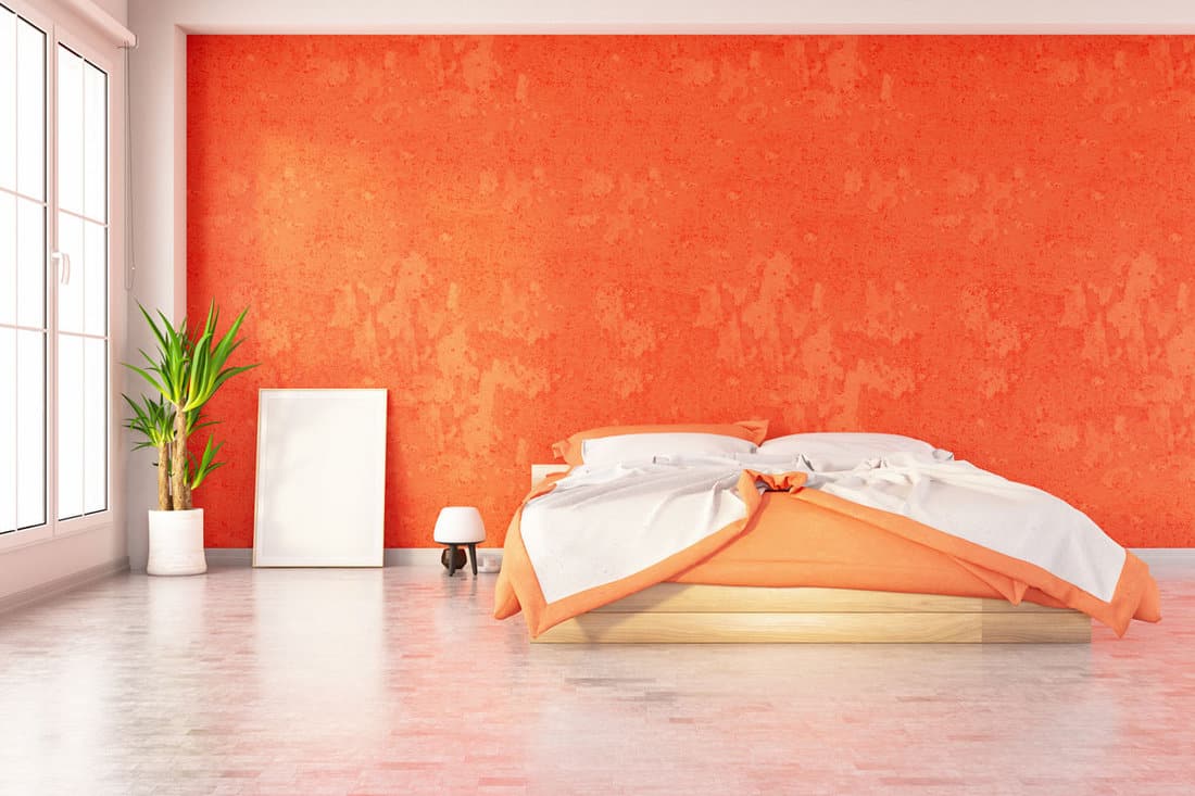 An orange bedroom with white mix and green plants