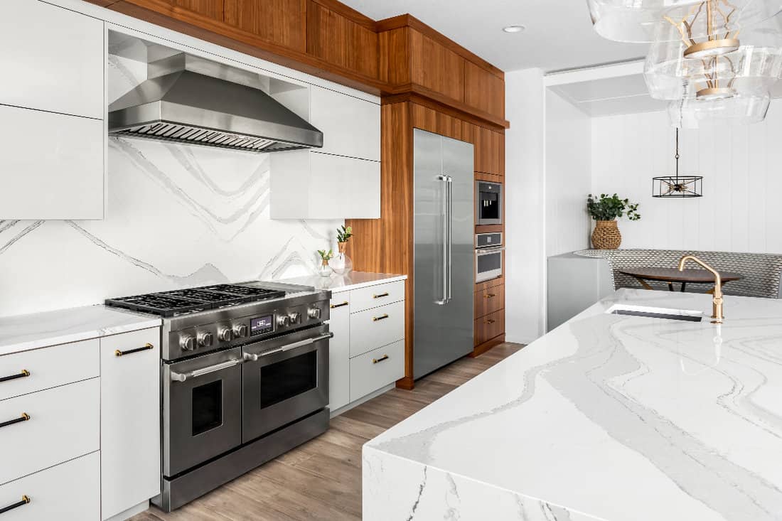 Beautiful kitchen in new luxury home with waterfall quartz island