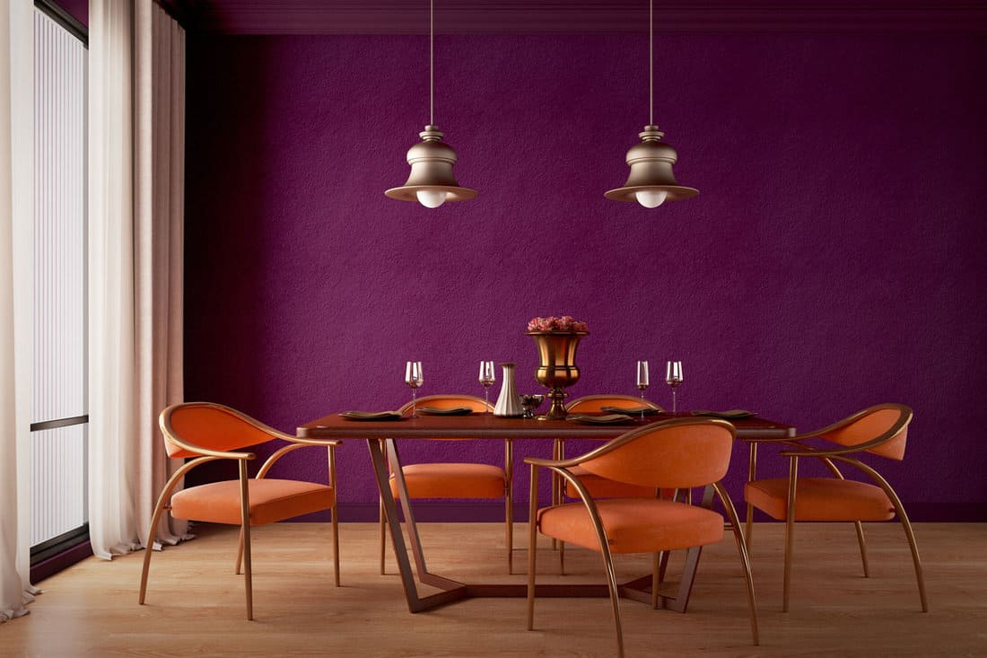 Dining room design with purple wall,orange chairs,table,lamp and wooden floor