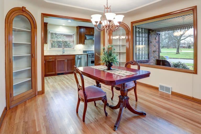 A dining room with vintage table set, built in cabinets and light hardwood floor, What Color Trim Is Best With Alabaster Walls? [15 Light & Dark Colors To Choose From!]