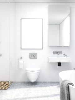 Front view of a bathroom interior with a shower, a toilet and a sink. There is a large window and a tall mirror on a wall.