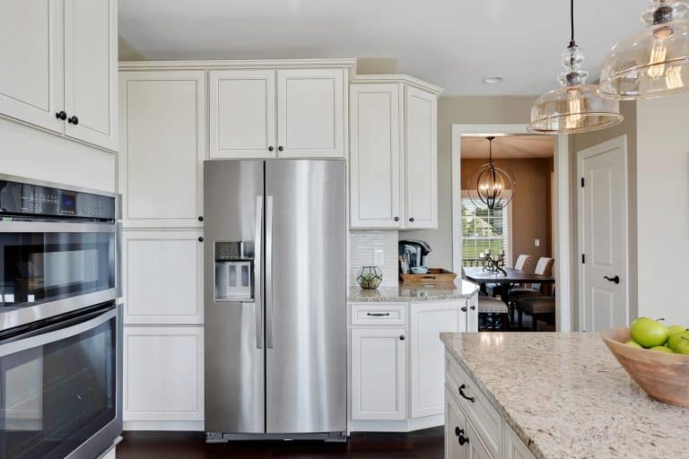 Granite countertops in kitchen with beautiful pendant lights over the island. French door refrigerator in new kitchen - My Whirlpool French Door Refrigerator Is Not Making Ice But Water Works - What To Do