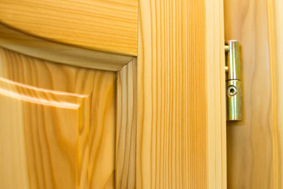 Golden barrel hinge on the wooden door