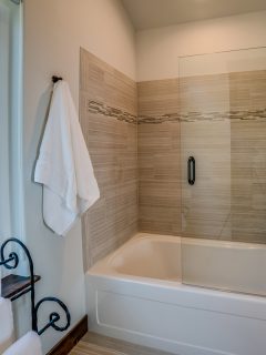 Interior of a luxurious modern bathroom with white painted walls and a glass wall bathtub, How To Fill Gaps Between A Tub Spout Or Shower Handle & Wall?