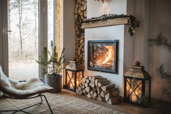Interior of log cabin with firewood and a fireplace, How Do You Fill Gaps Between A Wall And Fireplace? [Step By Step Guide]