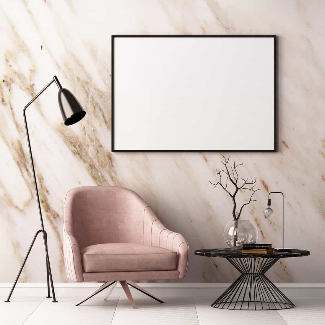 Mock up poster in the interior with an armchair and a table on the background of a marble wall,