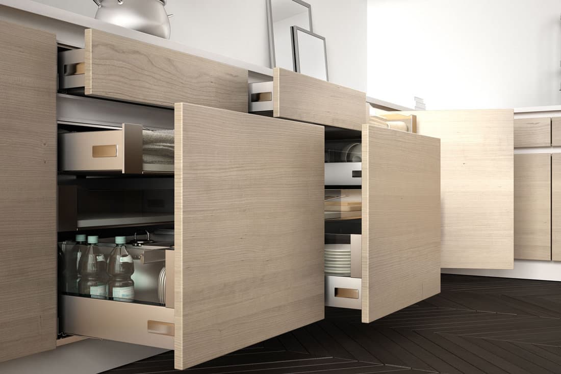 Modern kitchen, opened wooden drawers with accessories inside, solution for kitchen storage, minimali