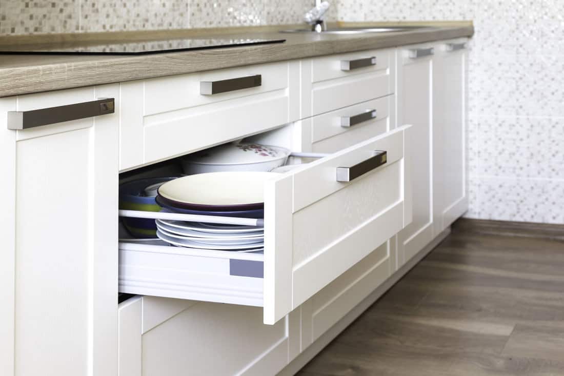Opened kitchen drawer with plates inside, a smart solution for kitchen storage and organizing