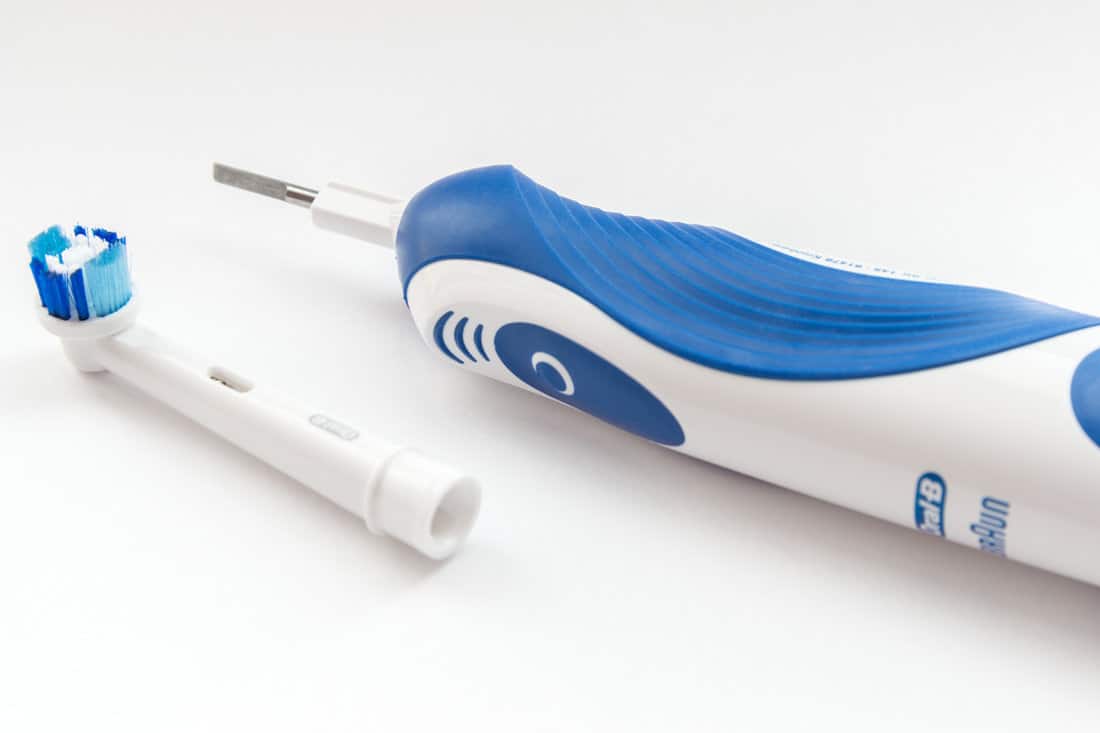 Oral-B electric toothbrush and replacement head on white background. Oral-B is a brand of oral hygiene products.