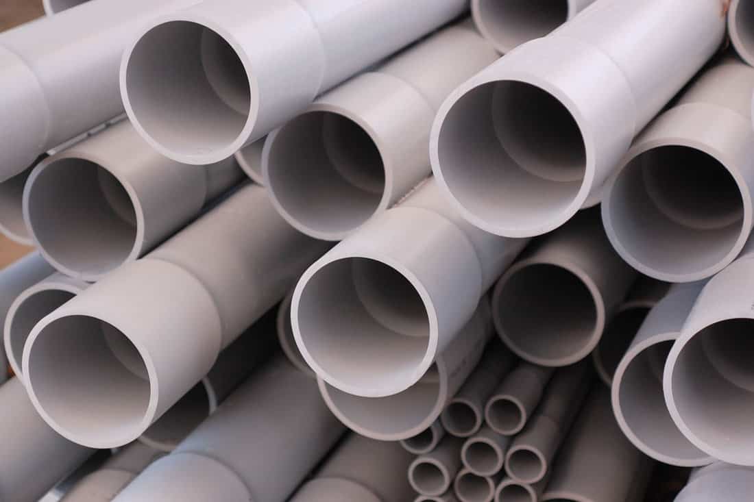 PVC conduit pipes on a stack. Nice gray texture background for construction site