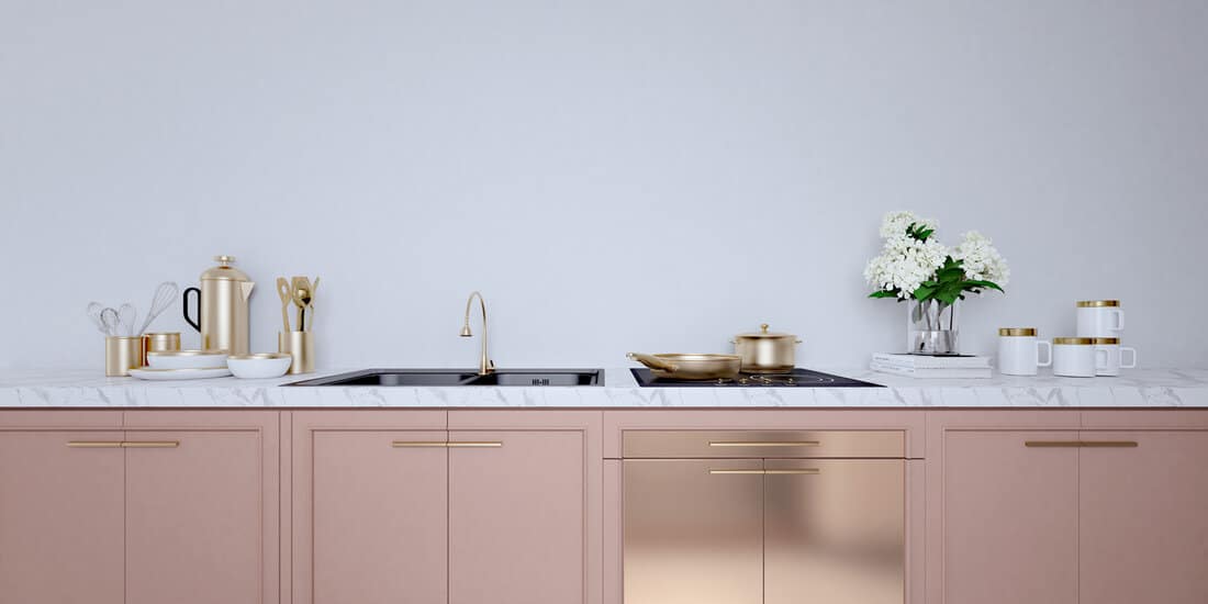 Rose gold color kitchen interior with white wall,white countertops.A close up