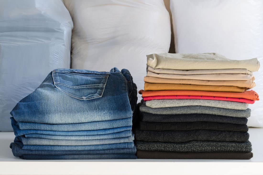 Stack of folded colored clothes in a laundry of denims