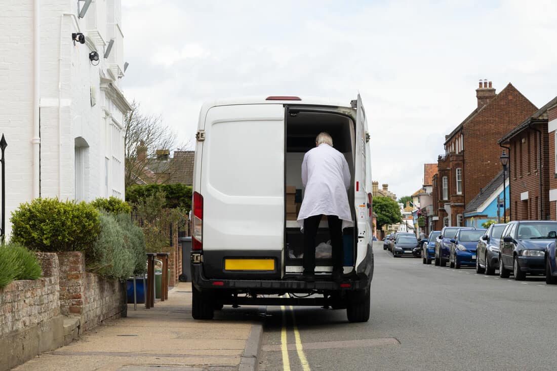 Van illegally parked on a double yellow line and obstructing the pavement for pedestrians