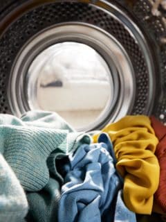 View Looking Out From Inside Washing Machine Filled With Laundry colored clothes, What Temperature Water Shrinks Clothes?