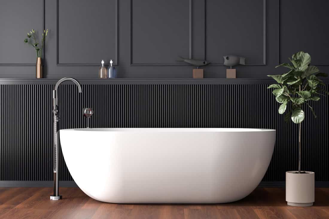 White free standing baththub in a dark paneled bathroom - Roman Bath Tubs: Sizes, Faucets, & Design Ideas