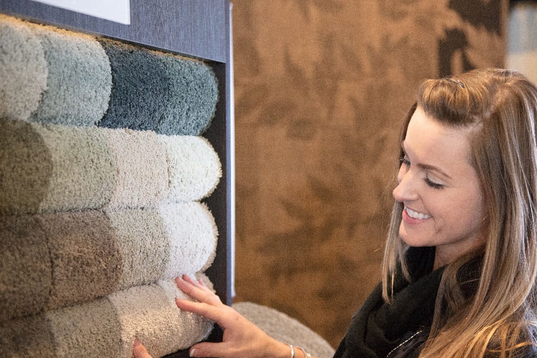 Woman shopping for carpeting and flooring in a home interiors store