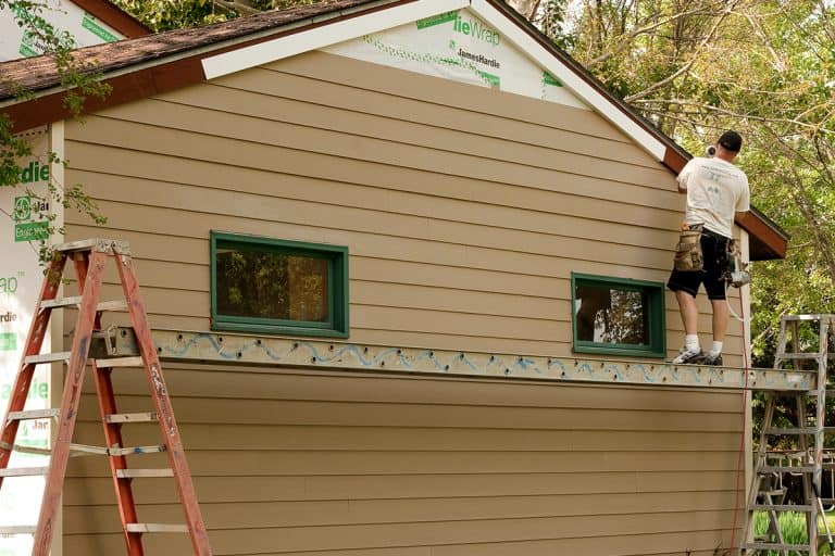 A worker installs hardie board siding and flashing to an existing structure, How To Install Hardie Siding On A House [Step By Step Guide]