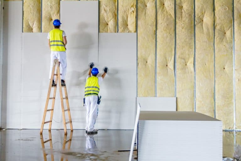 Workers are assembly gypsum wall. Plasterboard is under construction using wooden ladder., How To Replace A Drywall Section [Inc. Large and Small]