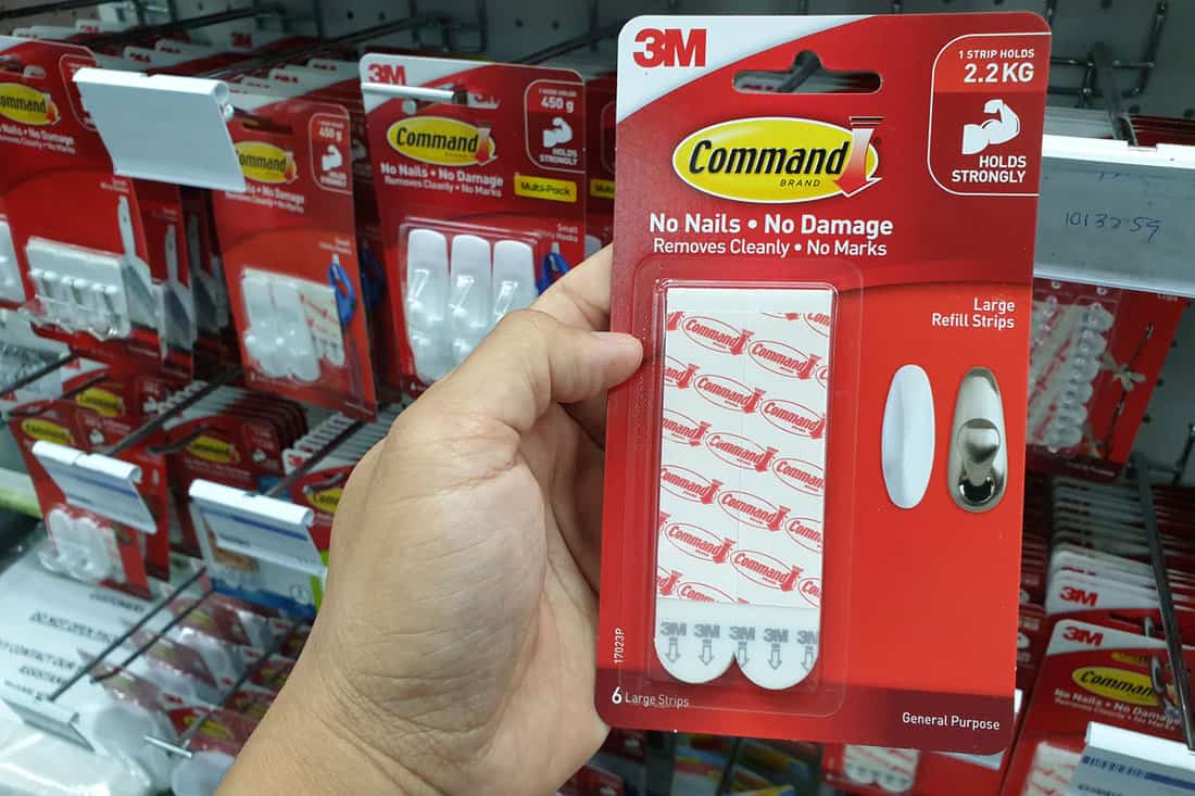 a man choosing a command strip hanging on a shelves of a store