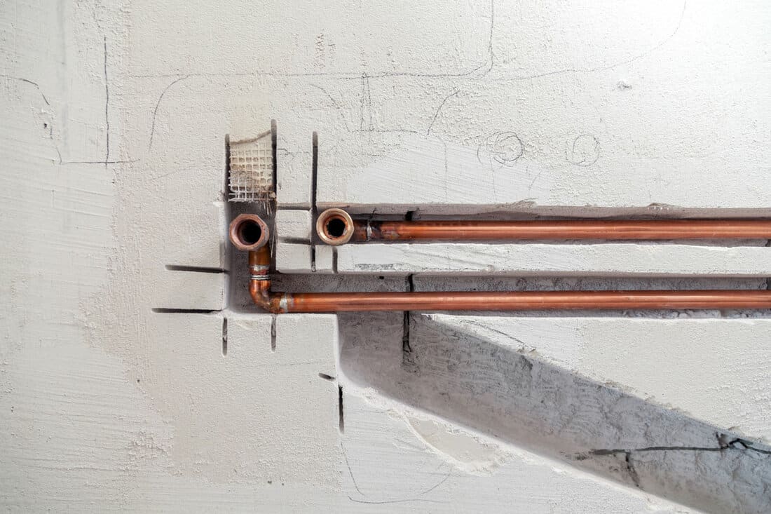 copper and plastic pipes, fittings on concrete wall