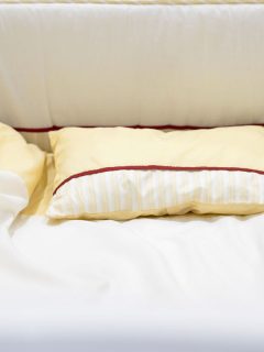 empty-baby-crib-matress-bed yellow pillow case, How To Fill Gaps Between The Crib & Mattress [Safely And Easily]