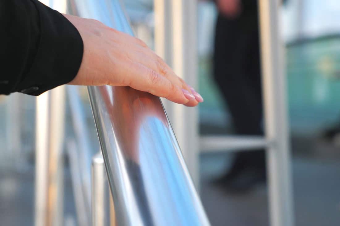 hand-businesswoman-sliding-on-metallic-handrail