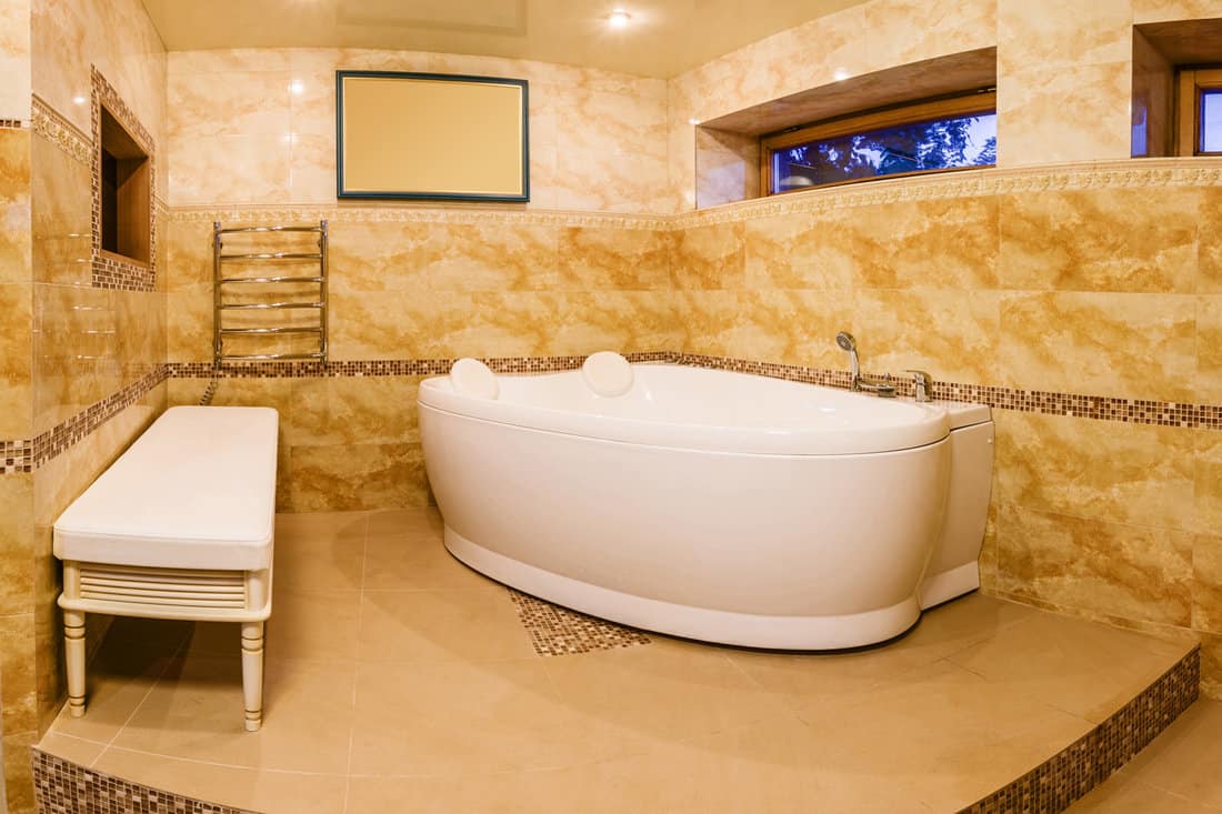 interior modern house, bathroom with marble tiles and hot tub. Bathroom in beige tones