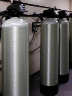 Several water softener filters for water stand in a row, Kinetico Vs Culligan Vs EcoWater Pros & Cons: Which Water Softener Is Right For Your Home?