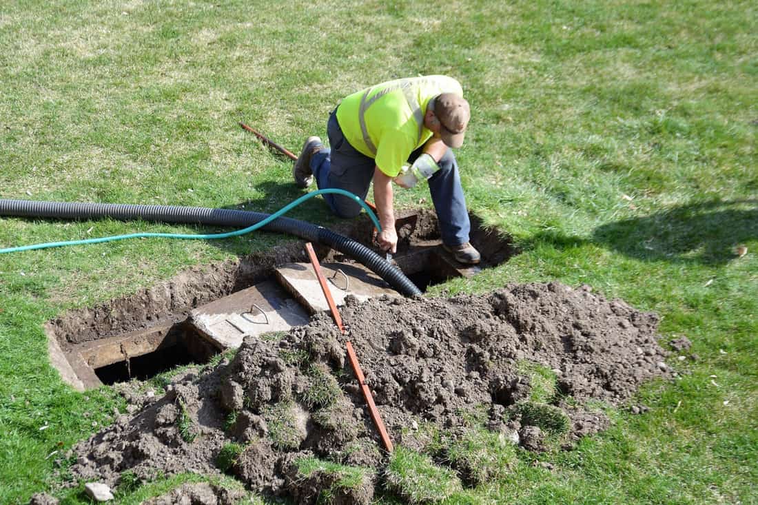 Man doing maintenance check on the septic tank