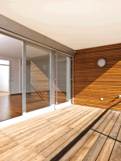 sunlit balcony with wooden floor and wall of an architectural contemporary home. Balcony Vs Patio Vs Terrace Vs Porch Pros, Cons, And Major Differences