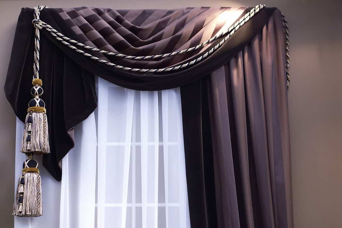 swag curtains with tassles on window with sheers