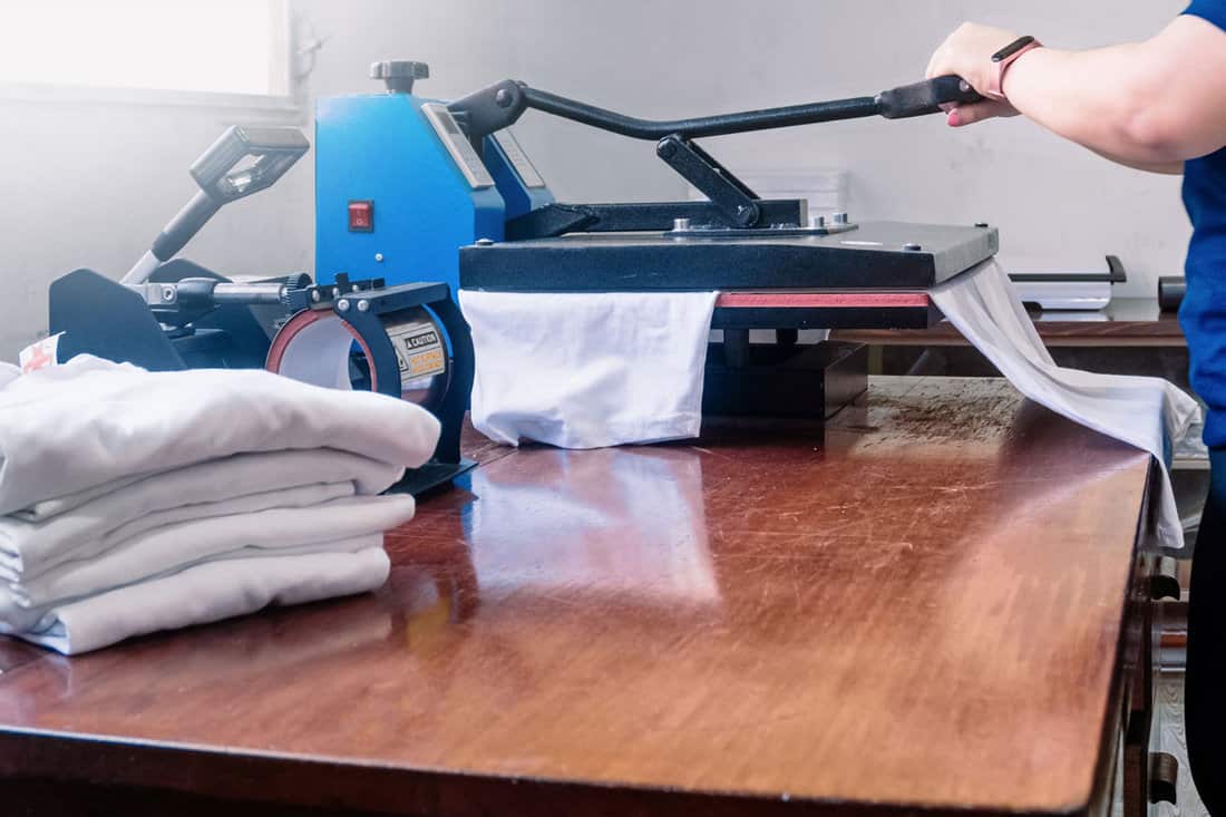 woman-manipulating-sublimation-machine-ironing-shirt