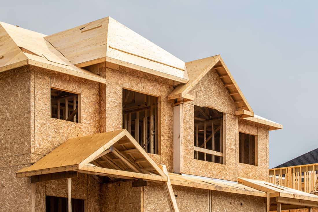 A residential house construction project showing plywood roof and dormer sheathing and oriented strand