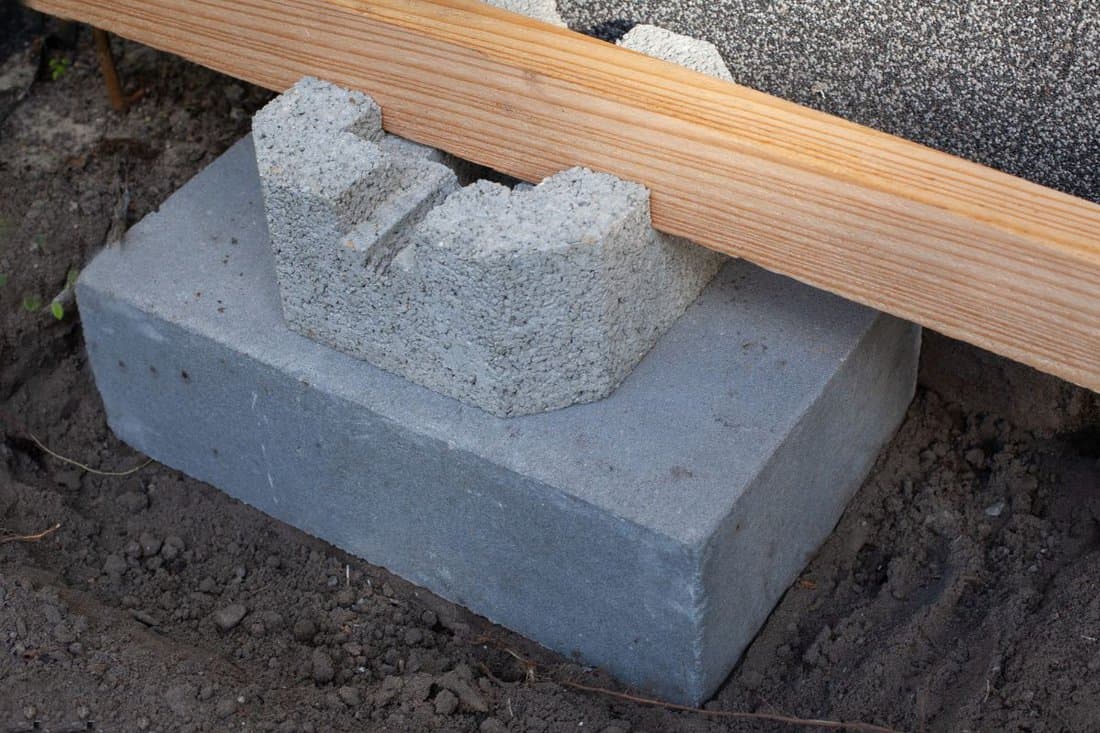 A shot of a cement deck footing installed on the ground.